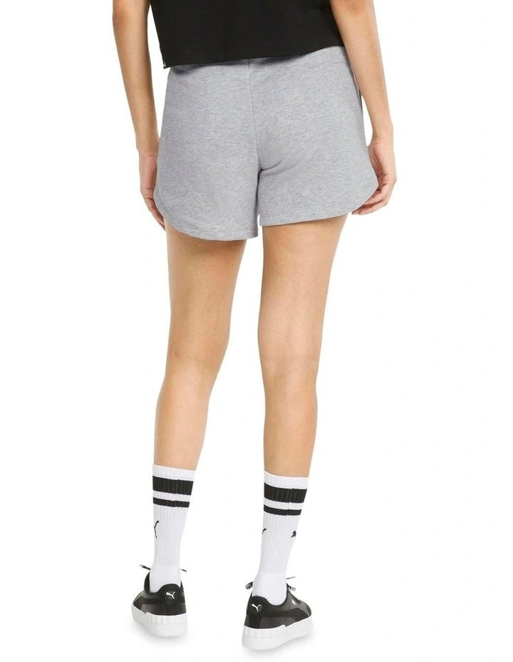 Person wearing gray Puma shorts on a white background