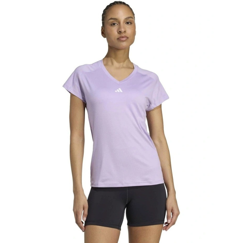 Woman wearing a light purple Adidas t-shirt on a white background