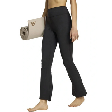Person wearing black yoga pants holding a beige yoga mat with a logo on a white background