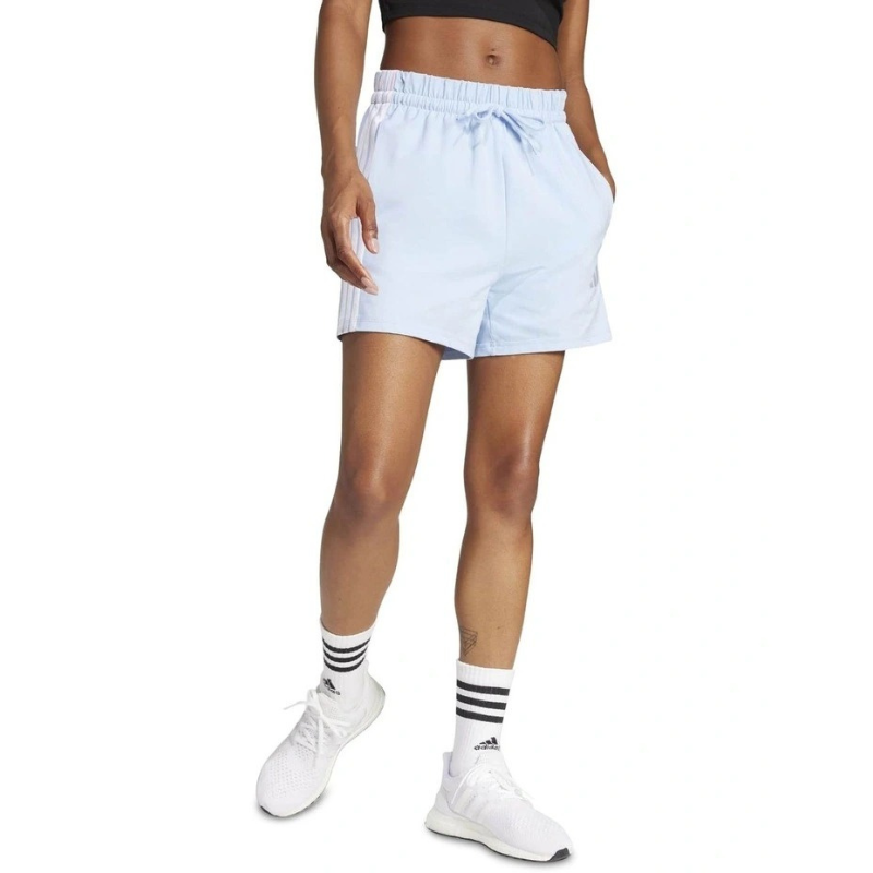 Person wearing light blue shorts and white sneakers on a white background