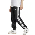Person wearing black Adidas tracksuit pants with white stripes and white sneakers on a white background