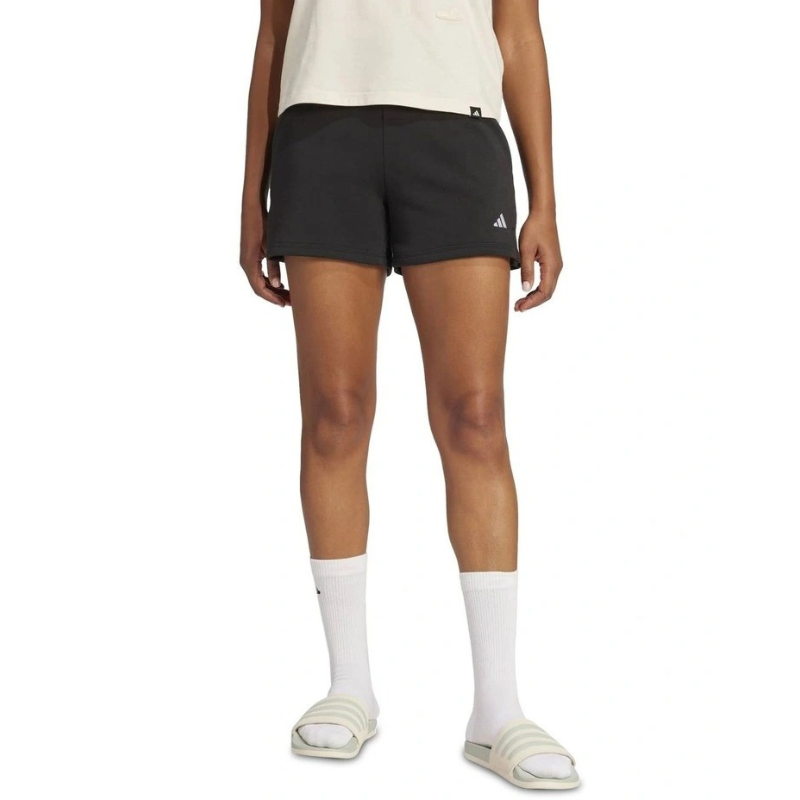Person wearing black Adidas shorts on a white background