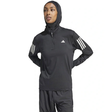 Person wearing a black Adidas hoodie and shorts on a white background
