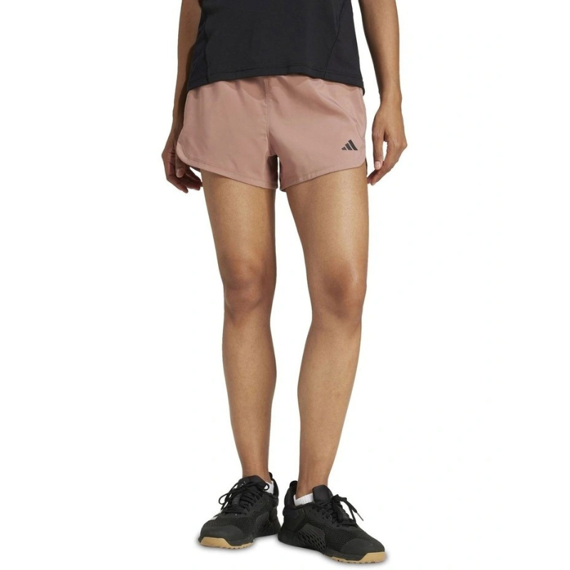 Person wearing pink Adidas shorts on a white background
