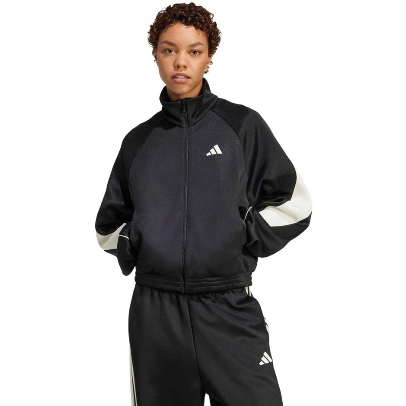 Person wearing a black Adidas tracksuit on a white background