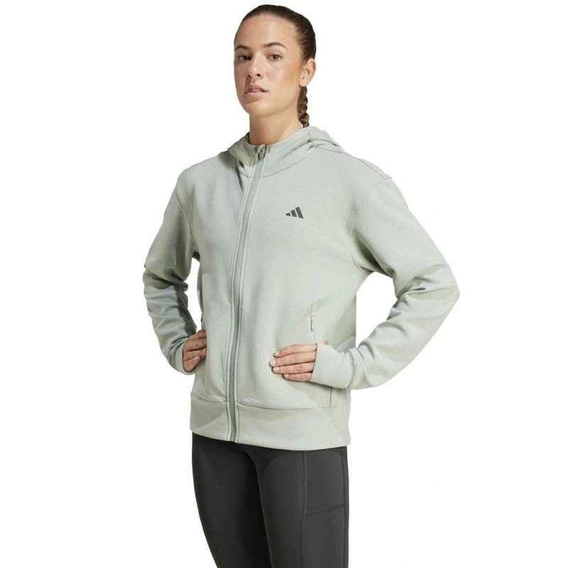 Woman wearing a light gray Adidas hoodie on a white background