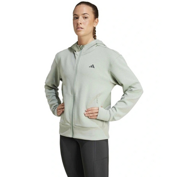 Woman wearing a light gray Adidas hoodie on a white background