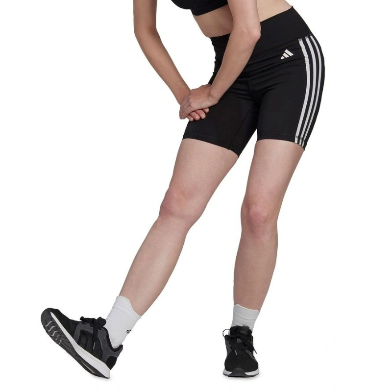 Person wearing black Adidas shorts with white stripes on a white background