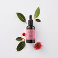 Sukin rosehip oil dropper bottle with leaves and flowers on a white background