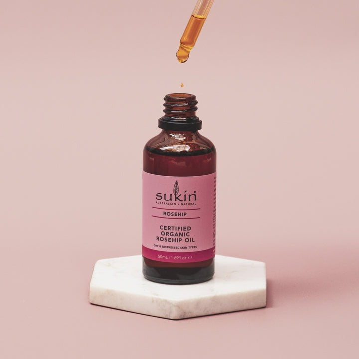 Sukin Certified Organic Bosnip Oil bottle with dropper on a pink background