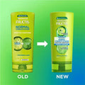 Comparison of an old and new Garnier Fructis conditioner bottle on a gradient green and blue background.