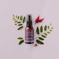 Sukin Intensive Firming Serum bottle with green leaves and red flowers on a light pink background