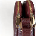 Red leather women’s shoulder bag with three compartments, elegant small satchel design featuring adjustable strap and gold hardware.