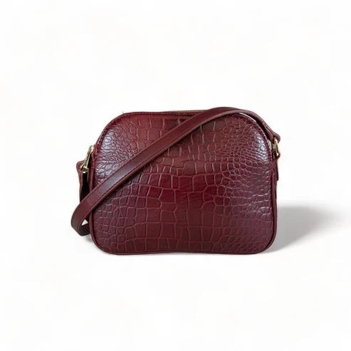 Dark red crocodile-embossed leather shoulder bag with gold hardware and adjustable crossbody strap, luxury women’s handbag on white background.