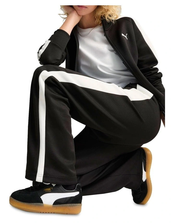 Black track pants with a white stripe and Puma logo on a white background