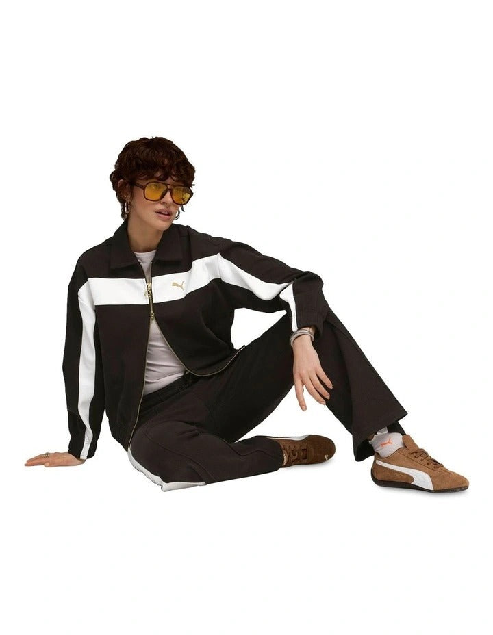 Person wearing a black and white tracksuit with a brand logo on a white background