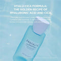 Blue skincare bottle with text about hyalu-cica formula on a light blue background