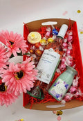 Purple Lavvish self-care gift box with skincare products, bath salts, soap bar, facial roller, and bath bomb displayed on purple floral background
