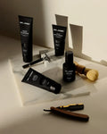 Virtue men’s skincare set with cleanser, exfoliator, moisturizer, face mask, and serum in sleek black packaging displayed with male models