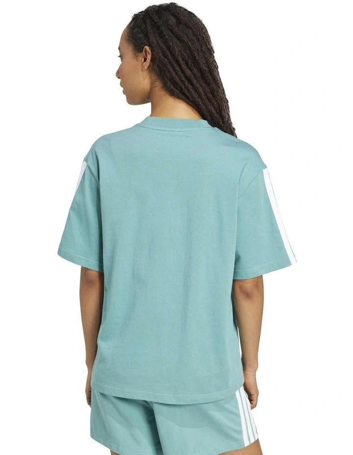 Person wearing a light blue Adidas outfit on a white background