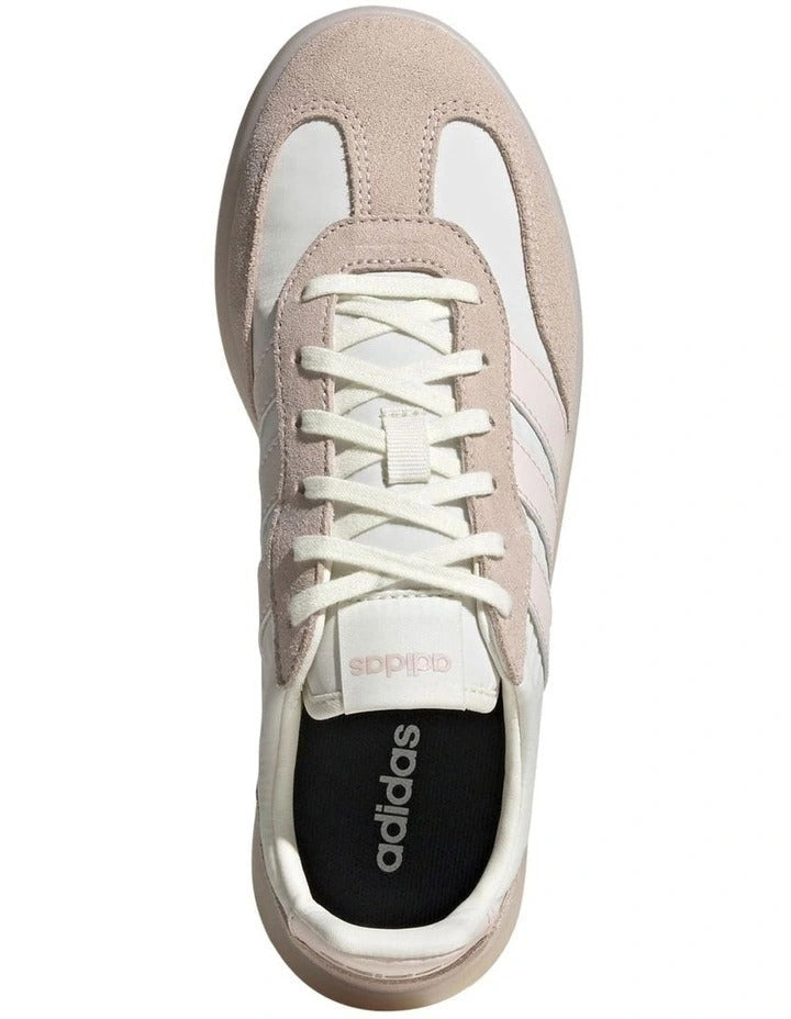 Beige and white sneaker with Adidas logo on a white background