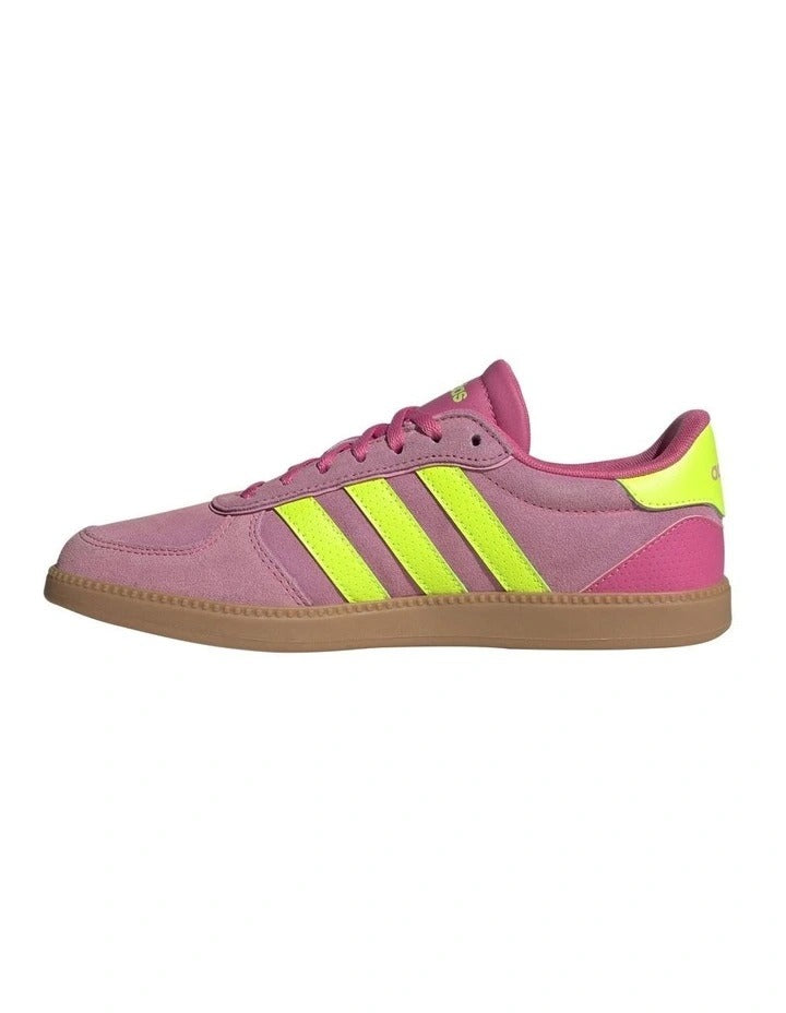 Pink Adidas sneaker with yellow stripes on a white background