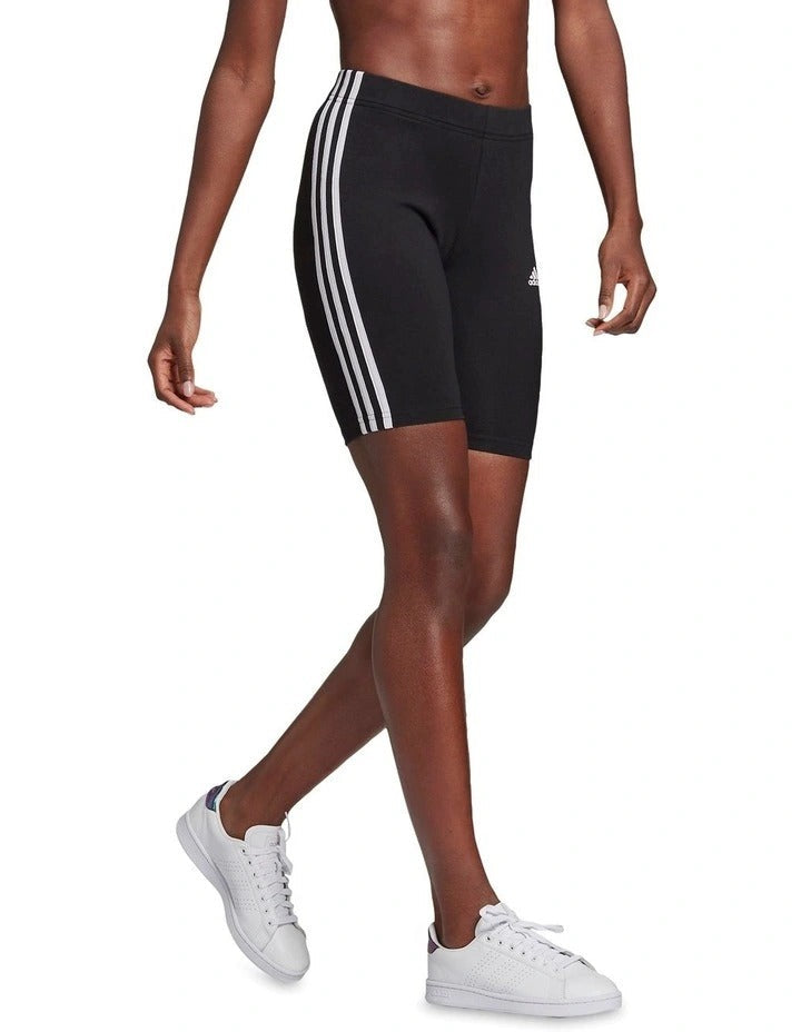 Black athletic shorts with white stripes worn by a person on a white background