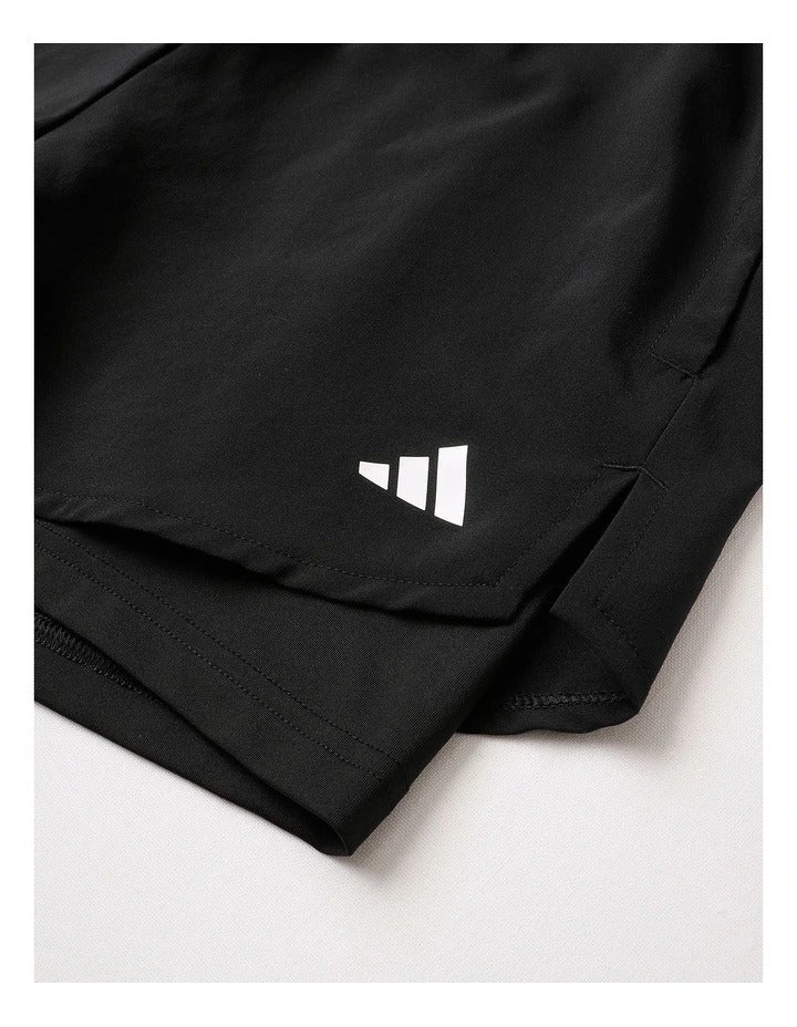 Black athletic shorts with a white logo on a white background